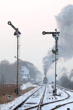 Old retro steam train starting from the station during wintertime