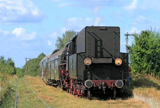 Old retro steam train stopped from the small station