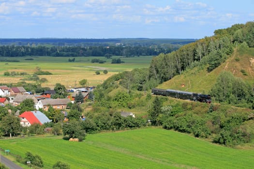 Beautiful hilly landscape with an old retro steam train