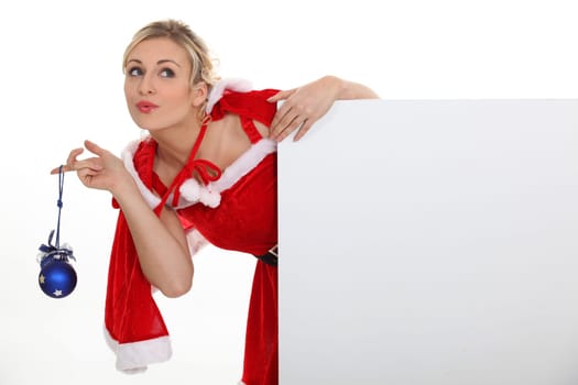 Woman dressed as Mrs. Claus and holding a blank board
