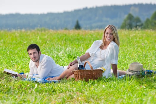 Picnic - Romantic happy couple in meadows nature reading book