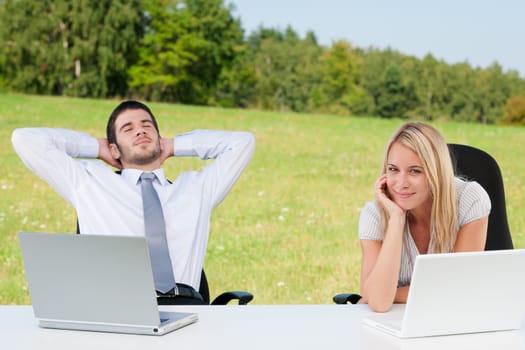 Business colleagues in sunny nature office relax with laptops