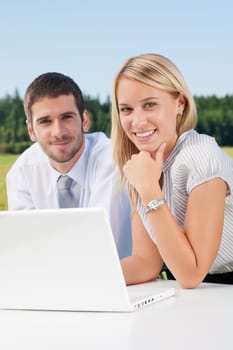 Business colleagues in nature office working on laptop smile