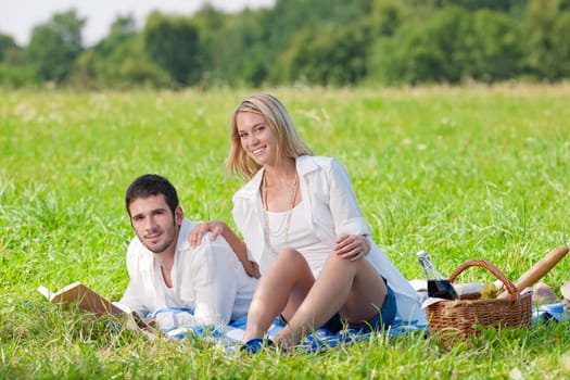 Picnic - Romantic happy couple in meadows nature reading book