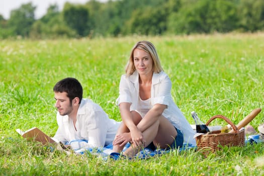 Picnic - Romantic happy couple in meadows nature reading book