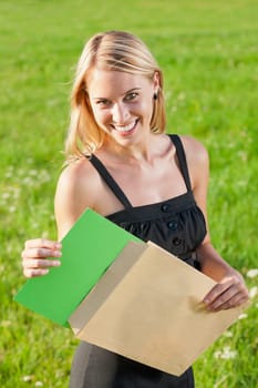 Surprise envelope young attractive businesswoman opening letter sunny meadow