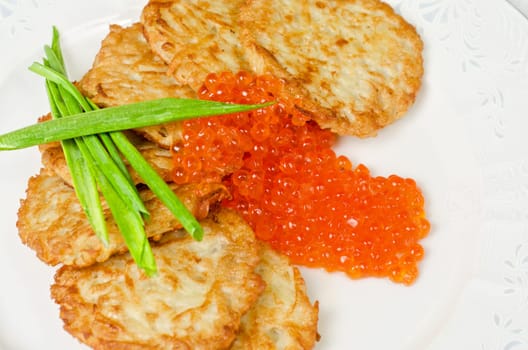 pancakes with red caviar and green onion closeup dish