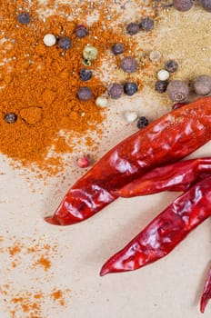 dried peppers and other kind of peppers spices on a brown background