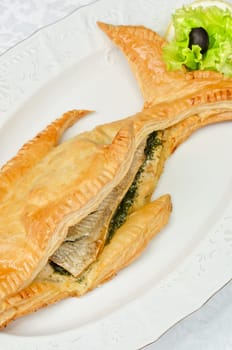 tasty dish of trout fish baked with greens at dough