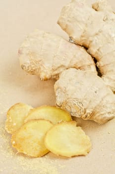 Fresh, dried and powdered ginger at brown background