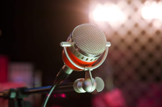 Closeup of audio microphone on stage background