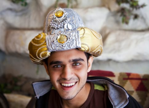 Happy Young Indian male teenager in a Fancy dress turban with big beaming smil and good set off top teeth, horizontal crop area and copy space