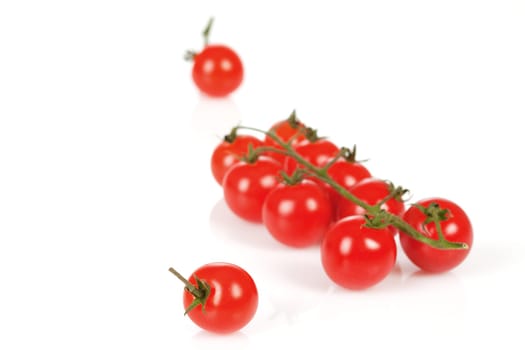 Cherry tomatoes on a stick with oil and pepper on a white background