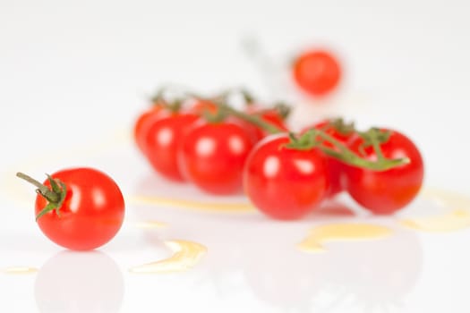 Cherry tomatoes on a stick with oil and pepper on a white background