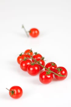 Cherry tomatoes on a stick with oil and pepper on a white background
