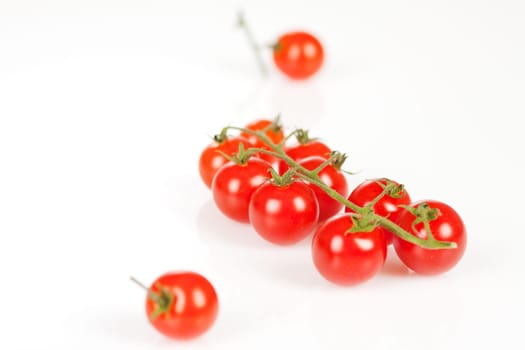 Cherry tomatoes on a stick with oil and pepper on a white background