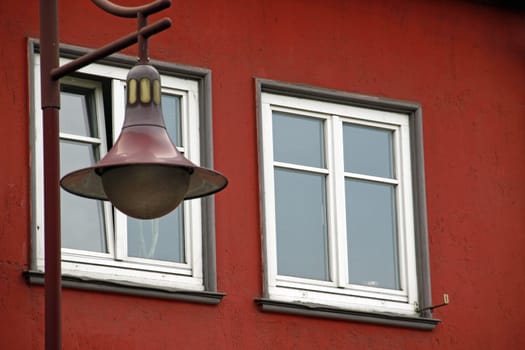 Red lantern in front of red house wall