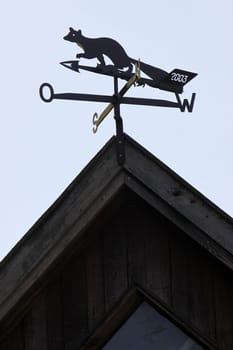 Weather vane in the shape of a marten on a roof
