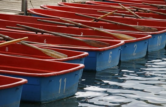 Blue and red rowing boats on a jetty