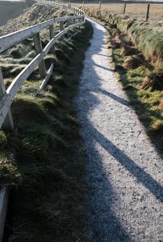 frosty winters view at ballybunion cliffside walk with atlantic view and fence shadows