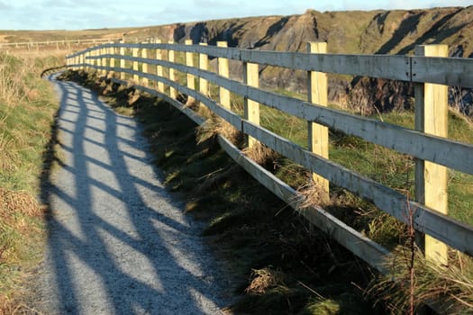 frosty winters view at ballybunion cliffside walk with atlantic view and fence shadows