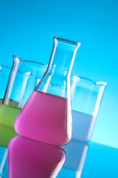 Laboratory Glassware - chemical flasks with colored solution. Focused on front flask with purple solution.