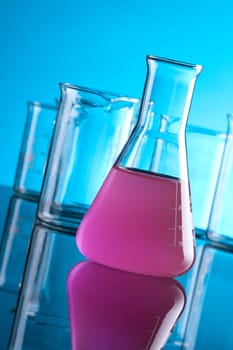 Laboratory Glassware - chemical flasks. Focused on front flask with purple solution.