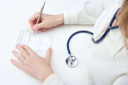 Female family doctor write prescription (recipe). Top view.