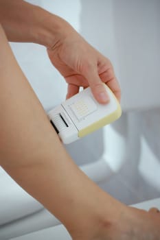 woman&#039 s leg shaving with an electric shaver