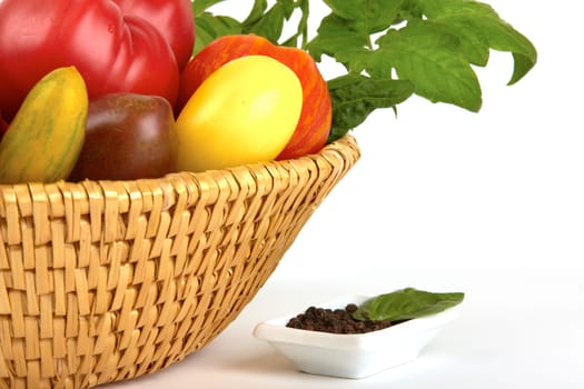 Basket of fresh organic tomatoes and peppercorns bowl