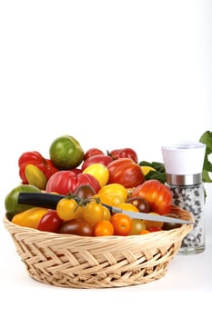 Basket of fresh organic tomatoes,paring knife and pepper salt mill / Basket of fre