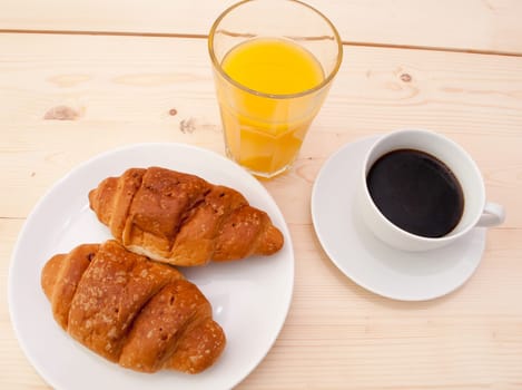 Breakfast - Croissants, Coffee and Orange Juice on Wooden Table