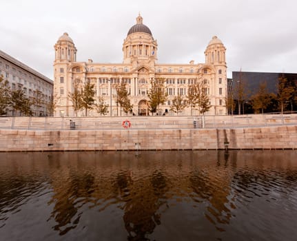 Reflection of three graces building on waterfront in Liverpool, England