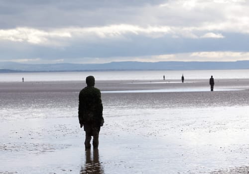 CROSBY BEACH, ENGLAND - SEPTEMBER 24: Statues forming Another Place by Antony Gormley on Crosby Beach on September 24, 2011. The statues are slowly rusting away with the tides and wind.