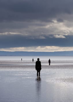 CROSBY BEACH, ENGLAND - SEPTEMBER 24: Statues forming Another Place by Antony Gormley on Crosby Beach on September 24, 2011. The statues are slowly rusting away with the tides and wind.