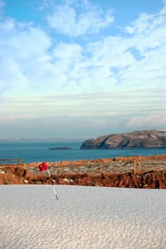 snow covering on a golf course in ireland in winter with sea and cliffs in background