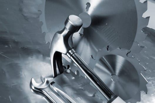 differant hand-tools, hammer, wrench, saw-blades, all in a blue toning concept