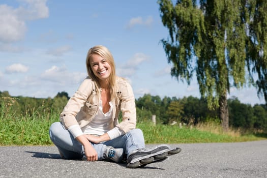 Inline skates young attractive woman wearing jeans sitting asphalt road