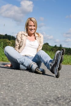 Inline skates young attractive woman wearing jeans sitting asphalt road