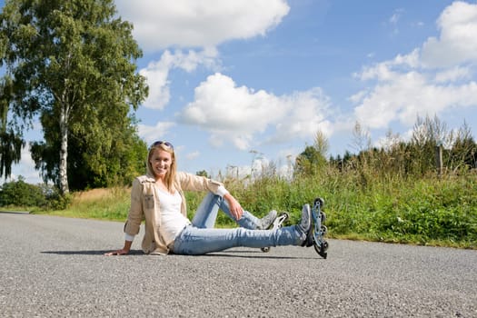 Inline skates young attractive woman wearing jeans sitting asphalt road