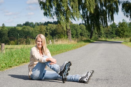 Inline skates young attractive woman wearing jeans sitting asphalt road