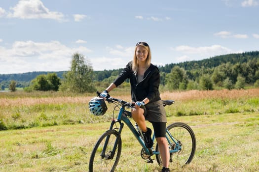 Mountain biking happy sportive girl relax in meadows sunny countryside
