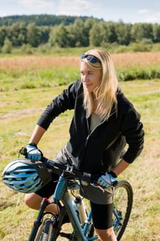 Mountain biking happy sportive girl relax in meadows sunny countryside