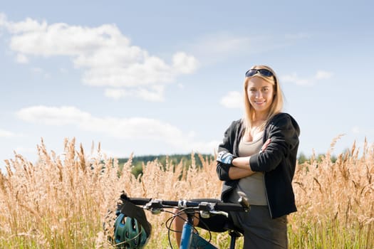 Mountain biking happy young woman relax in cornfield sunny countryside