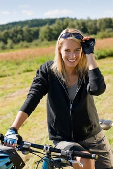 Mountain biking happy sportive girl relax in meadows sunny countryside