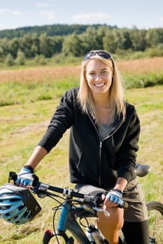 Mountain biking happy sportive girl relax in meadows sunny countryside