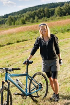 Mountain biking happy sportive girl relax in meadows sunny countryside