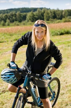 Mountain biking happy sportive girl relax in meadows sunny countryside