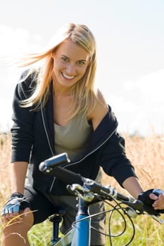 Mountain biking happy young woman relax in cornfield sunny countryside
