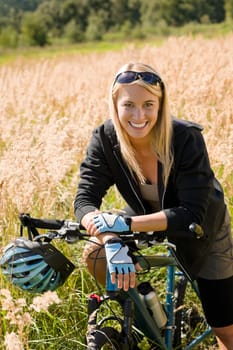 Mountain biking happy young woman relax in cornfield sunny countryside